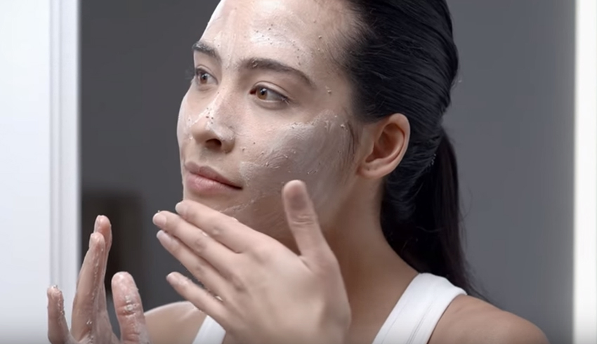 A woman applying an organic sugar scrub to her face. 
